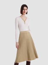 A lady wears a V-neck sweater and a pleated skirt.